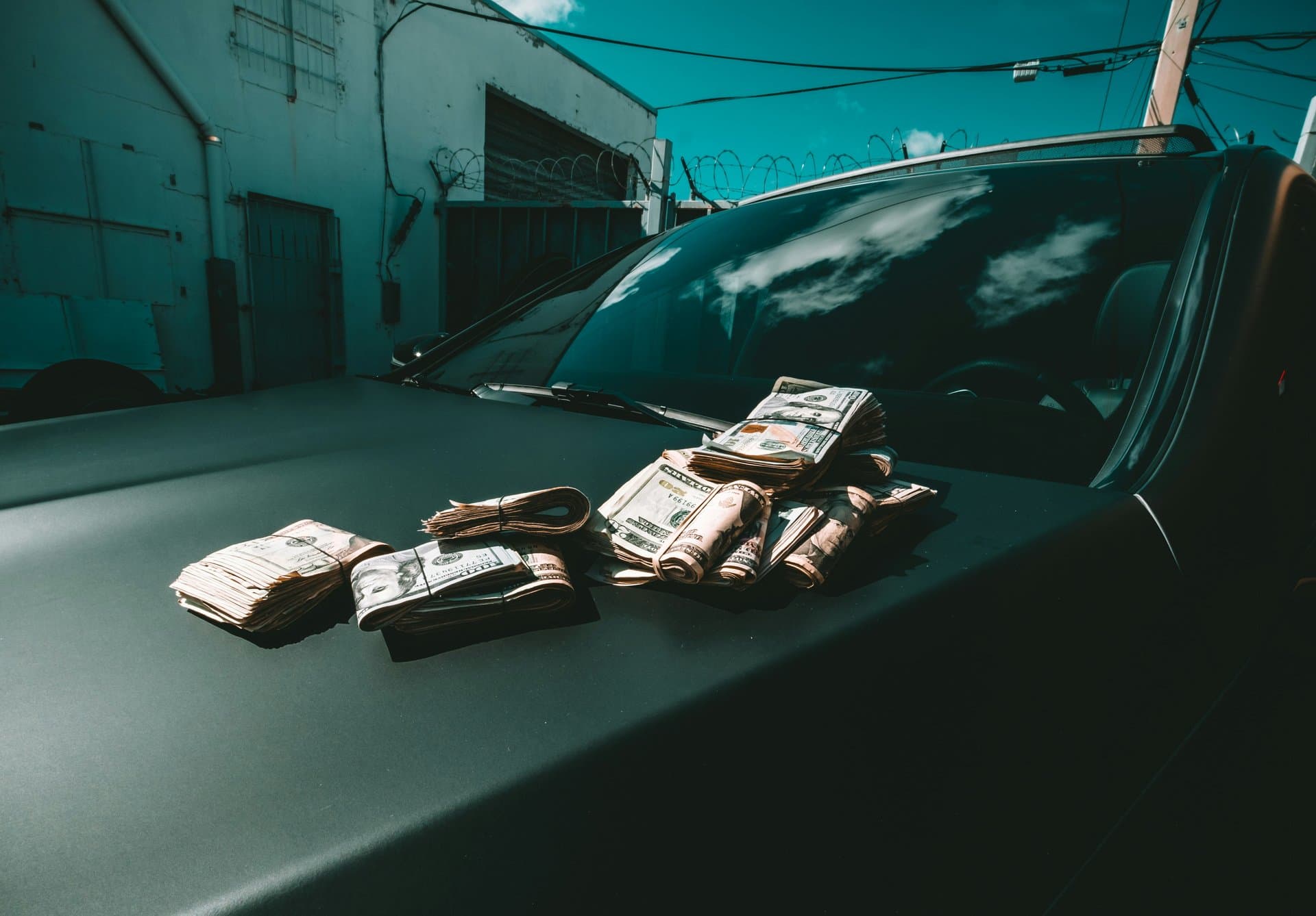 bundles of dollars lying on a car hood