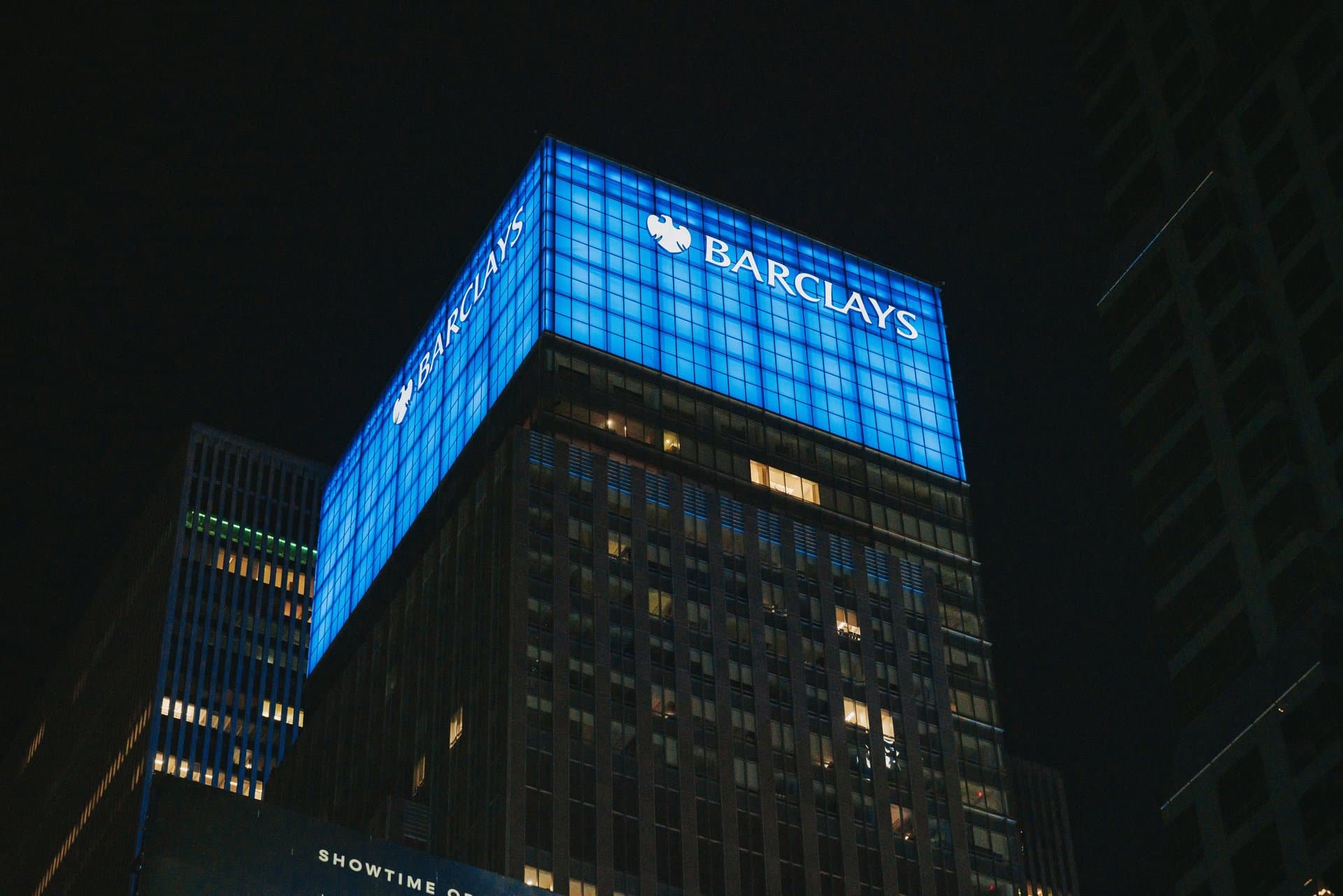 a blue building with barclays board