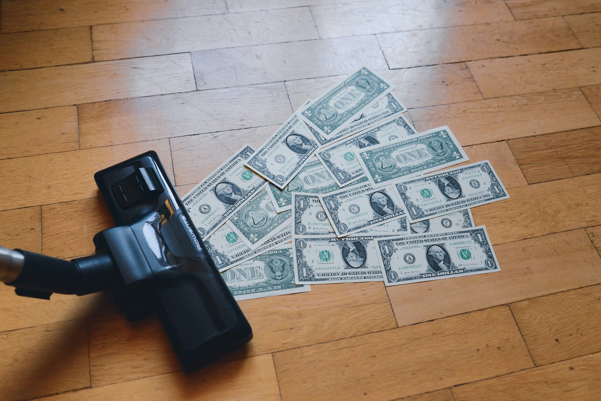 dollars being sucked into a vaccuum cleaner