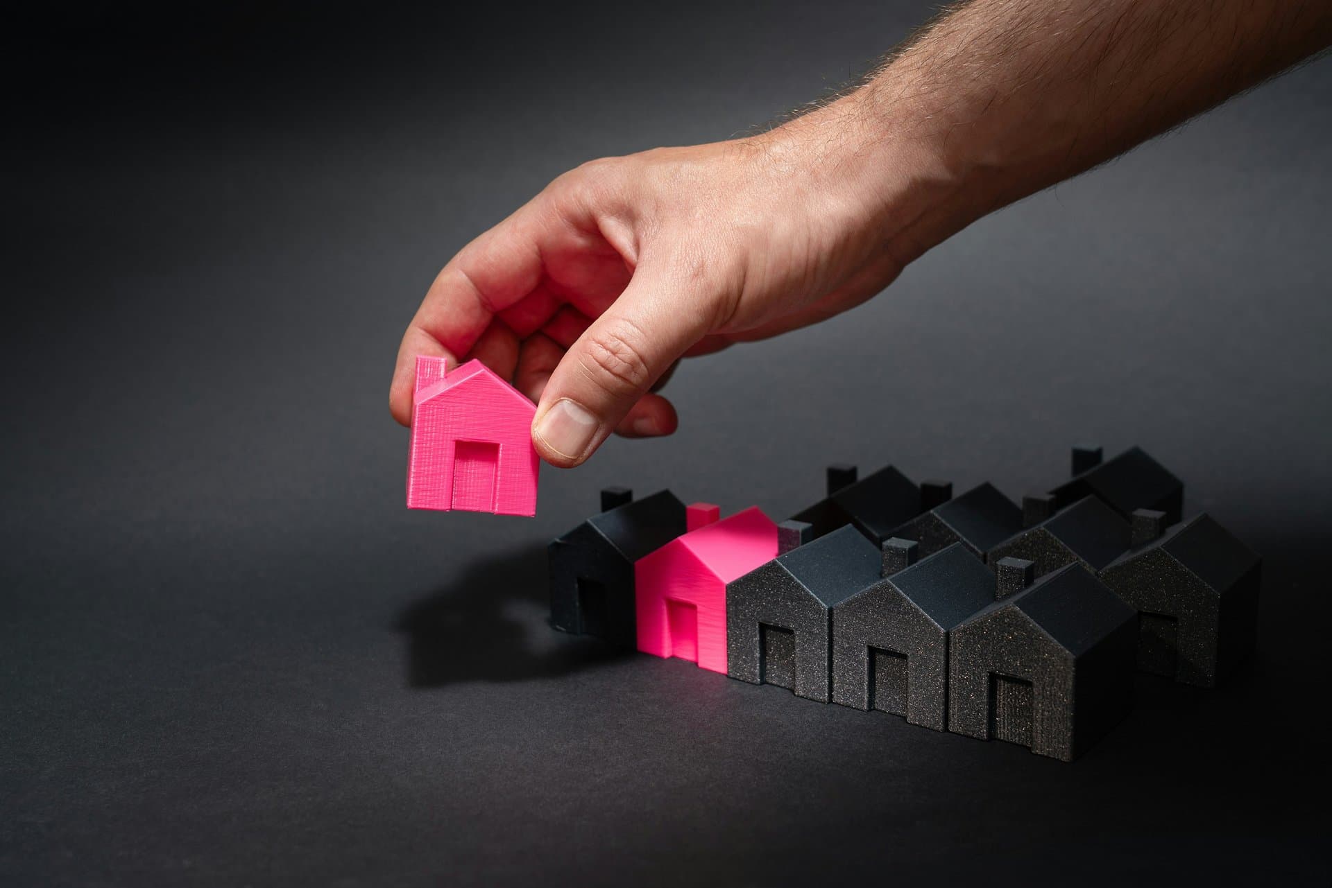 a hand placing toy homes