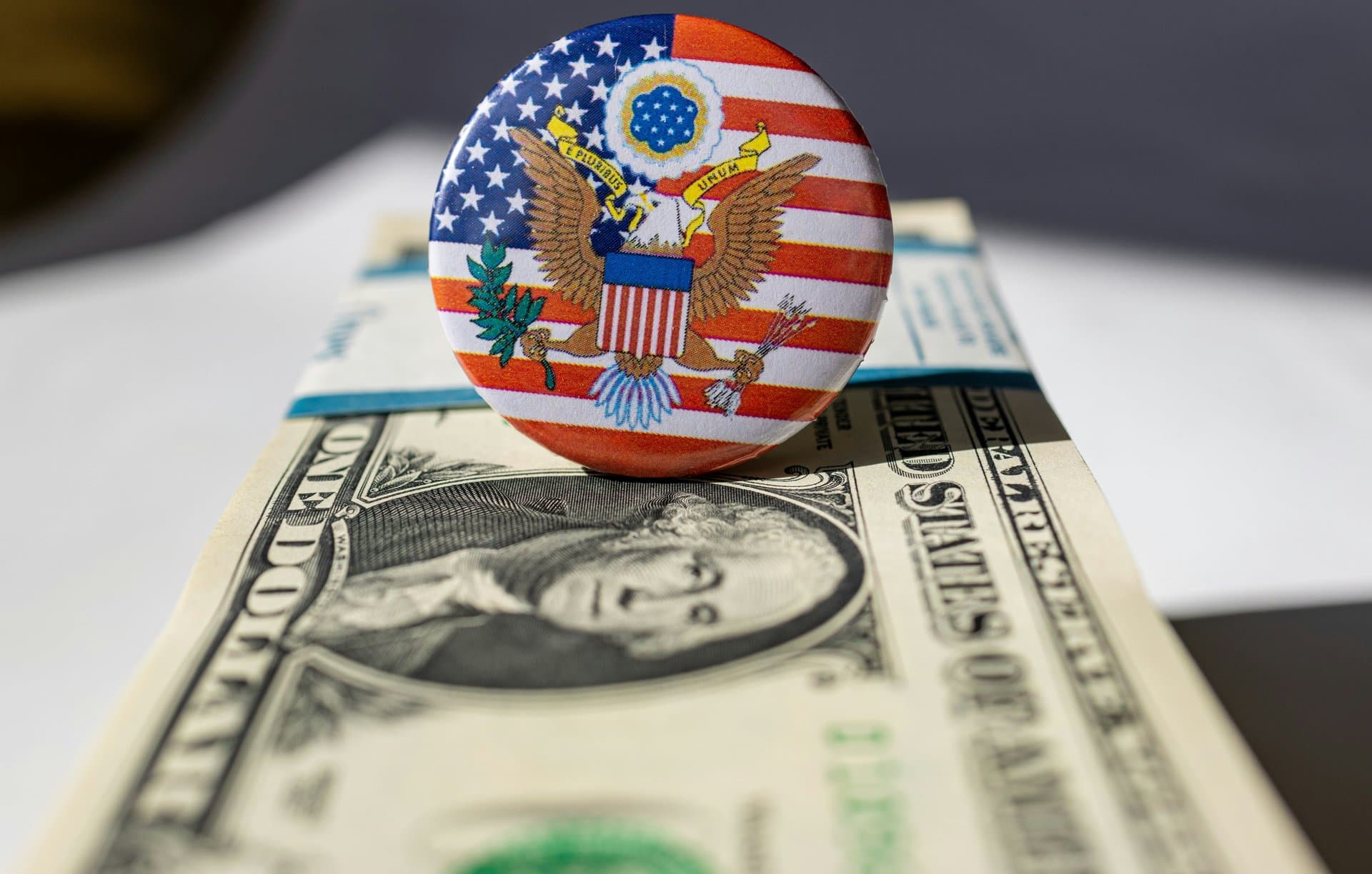 an american pin badge on a US dollar bill