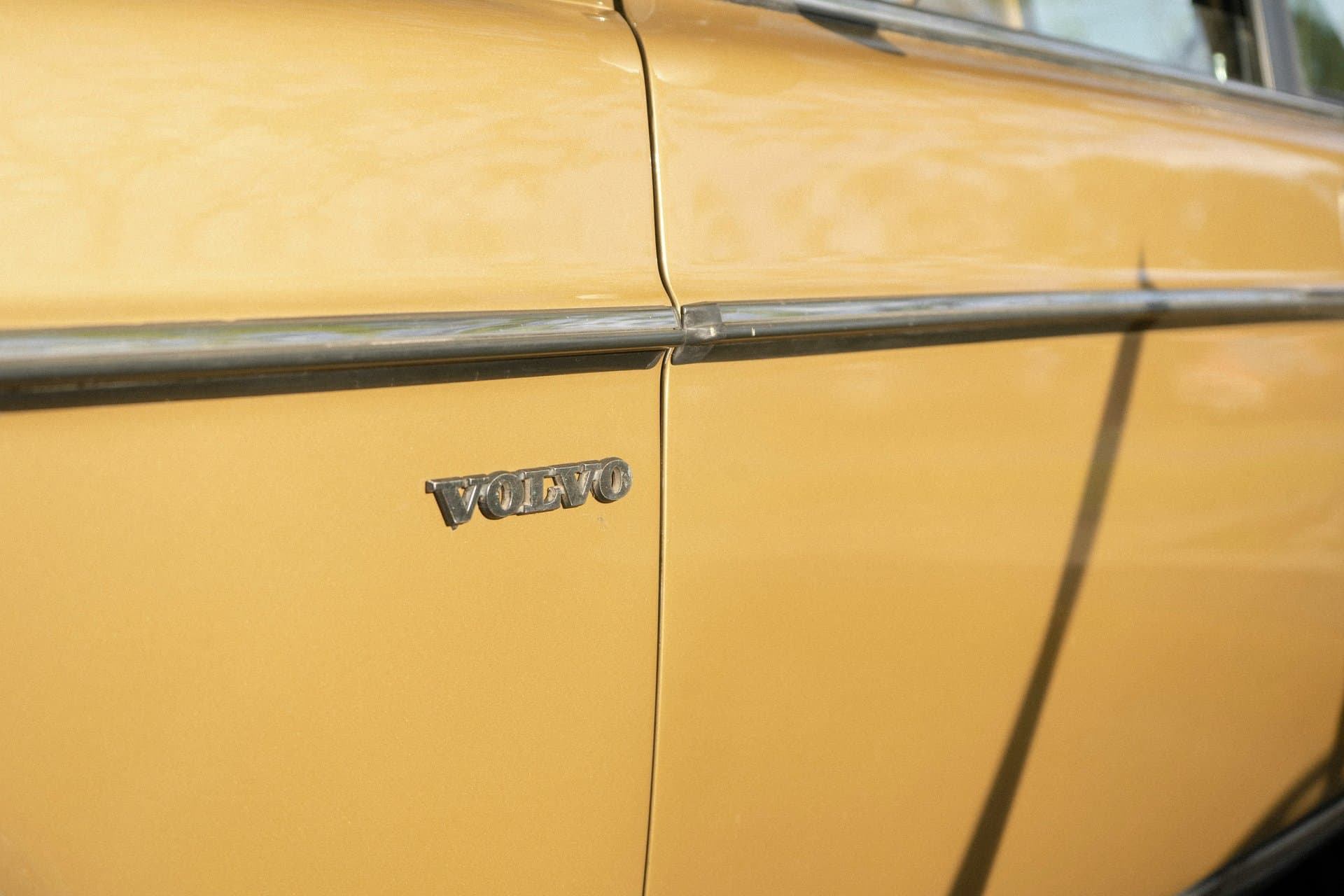 A yellow car fender with Volvo logo