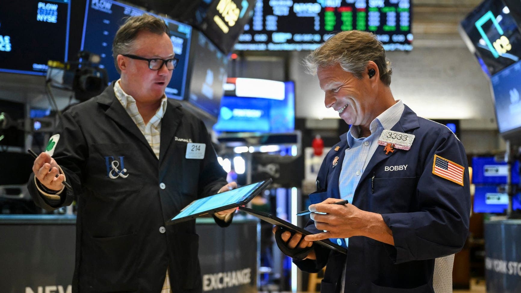 two men on the floor of the New York Stock Exchange (NYSE)