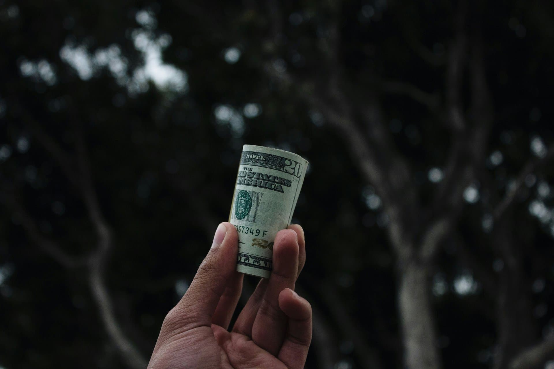 hand holding a dollar bill roll