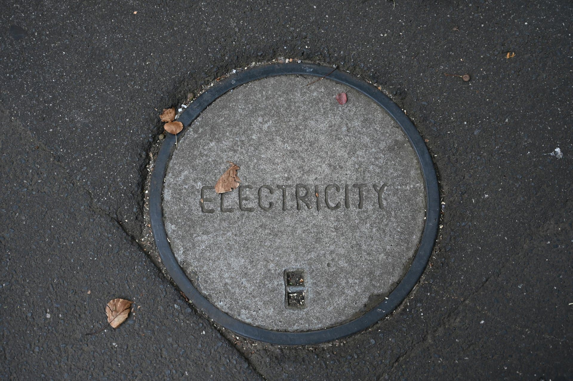 a sewer cap with electricity written on it.