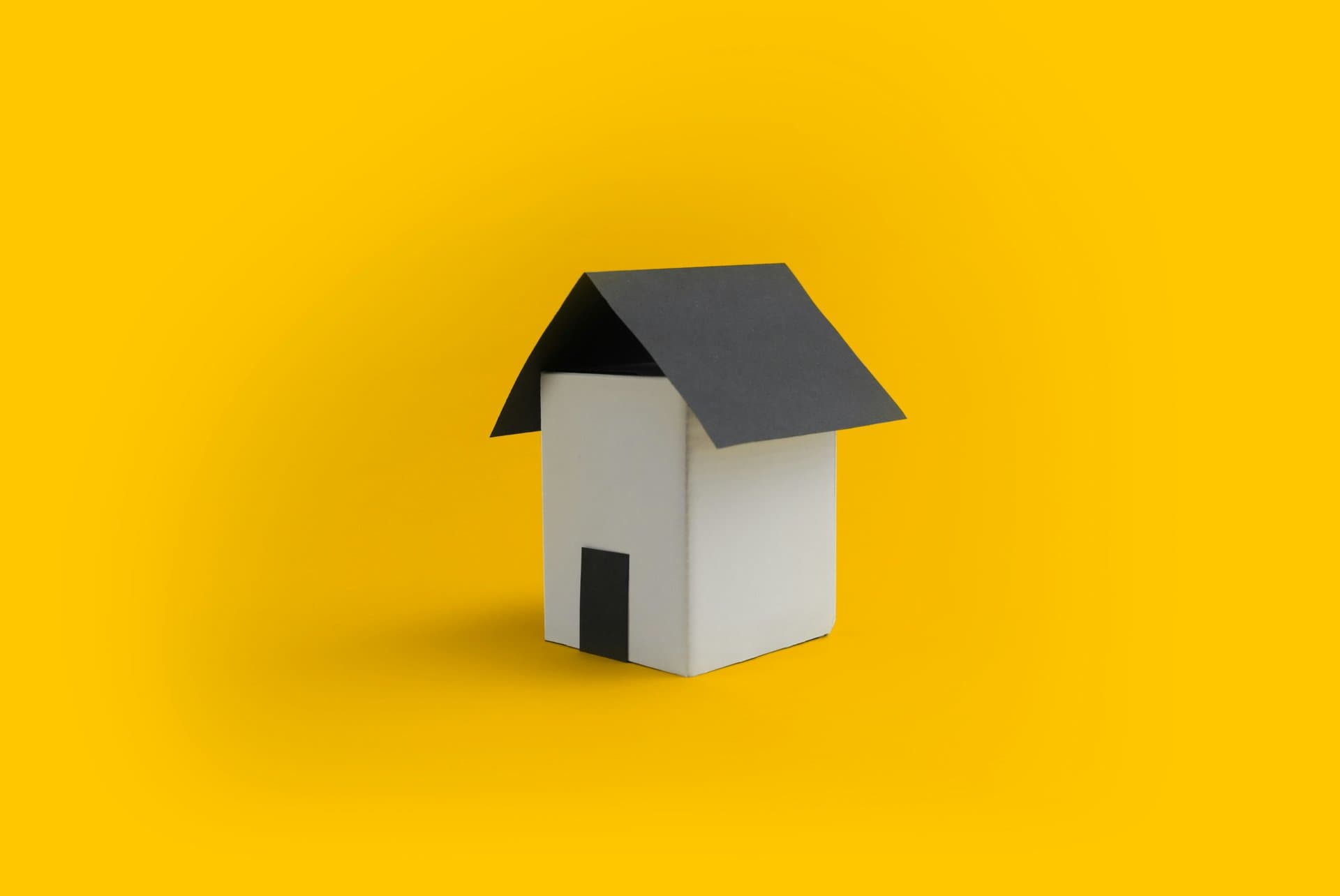 a toy house on a yellow background