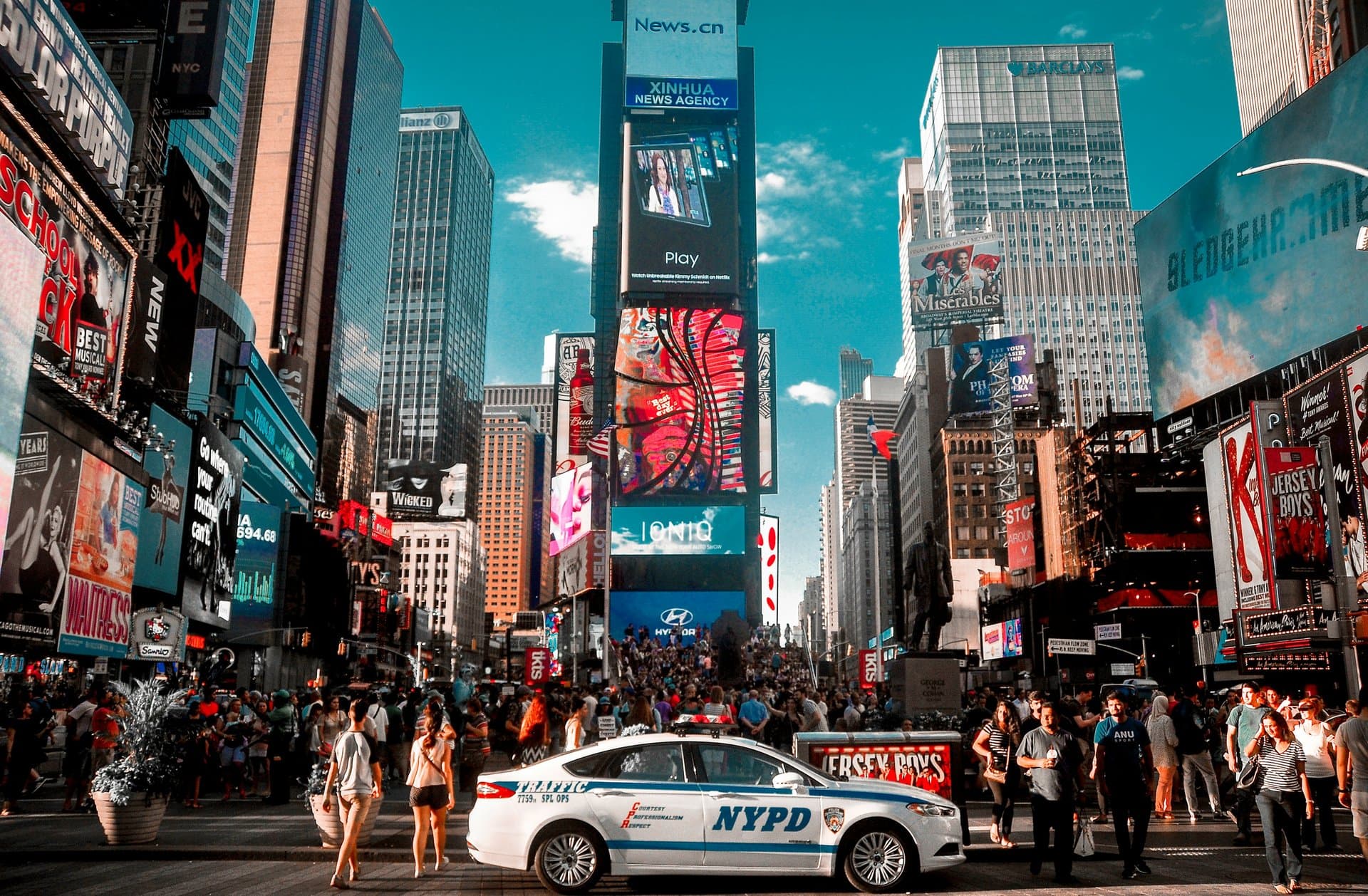 a busy street surrounded by advertising on buildings