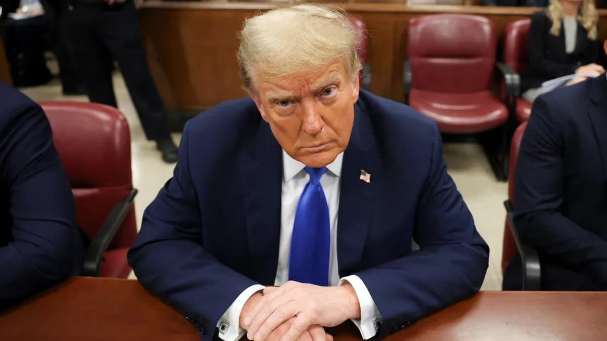 a suited blonde man sitting on a table