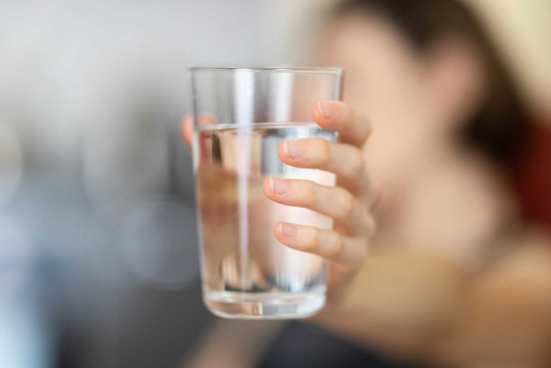 a hand holding glass of drinking water