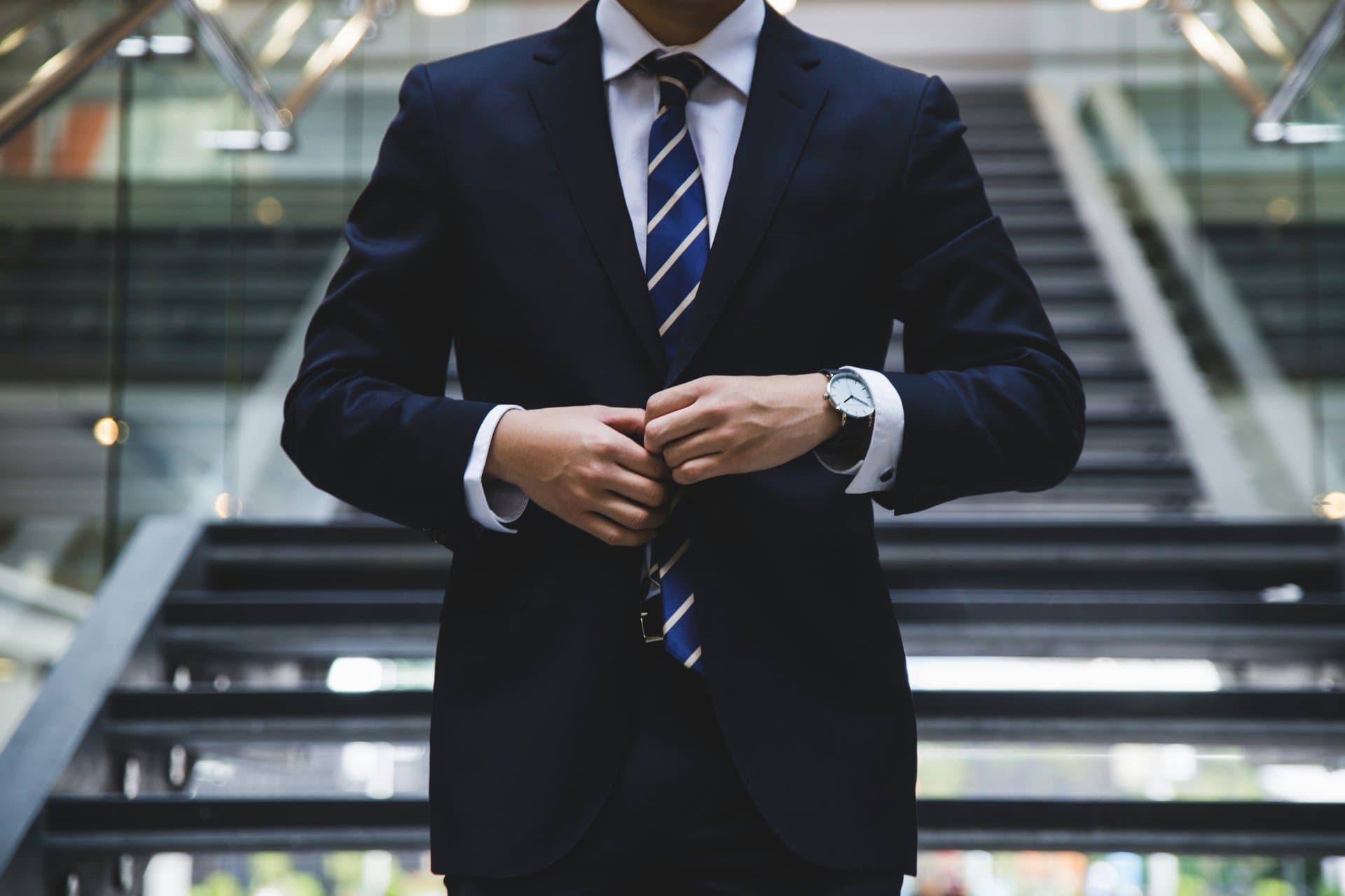 a man buttoning blue suit