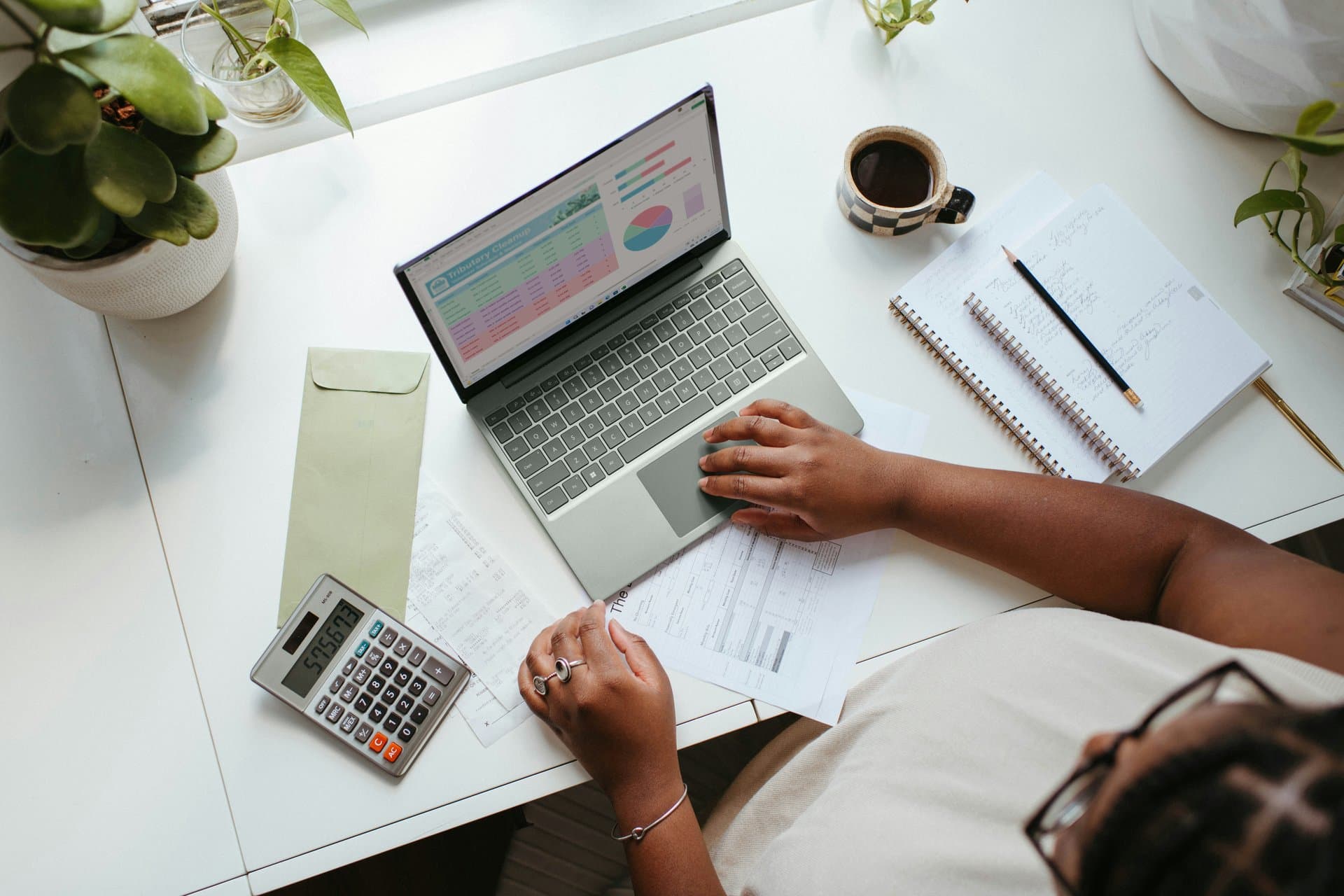 Top shot of a person sitting with laptop and calculator
