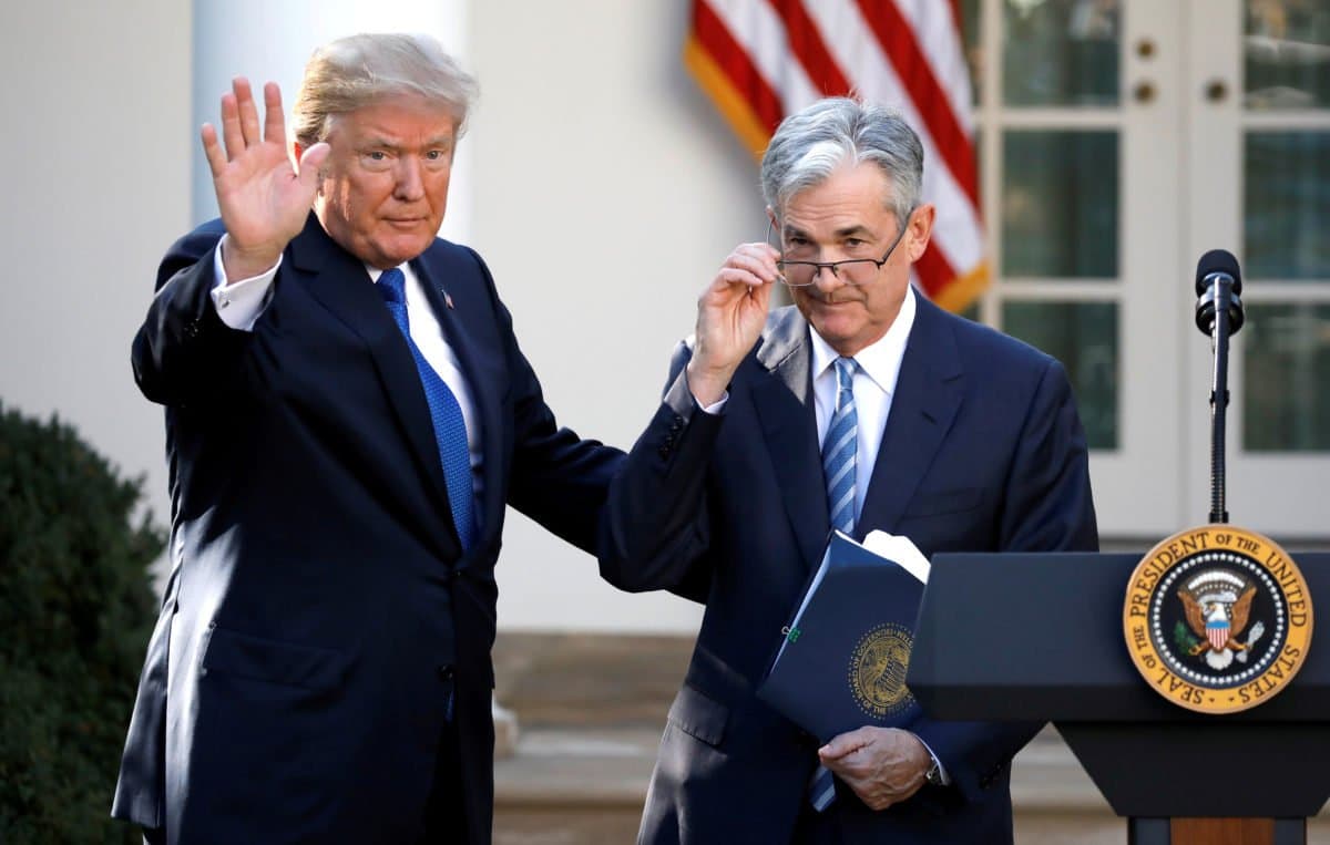 Donald Trump and Jerome Powell standing next to a podium