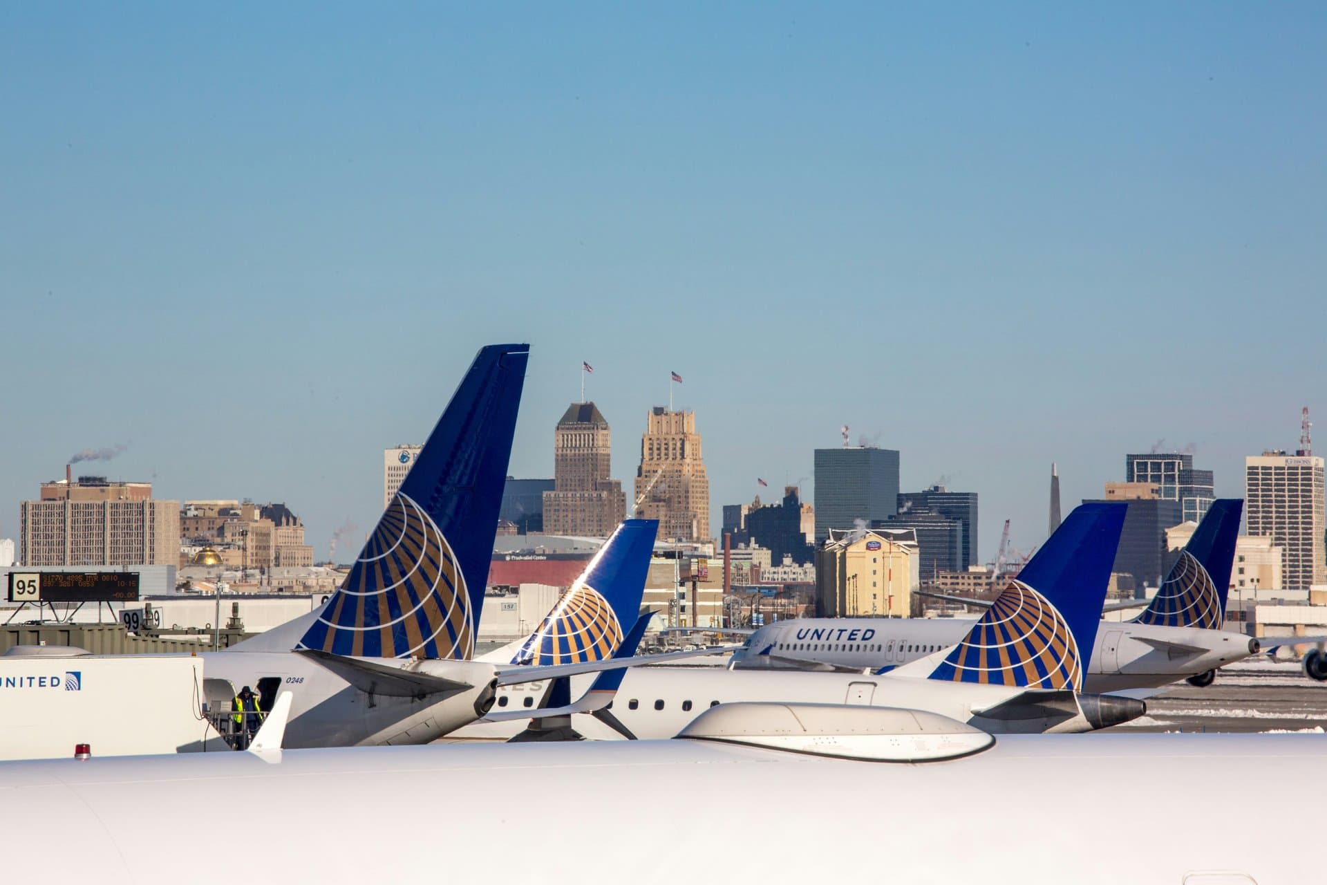 multiple united airlines planes parked near the hanger