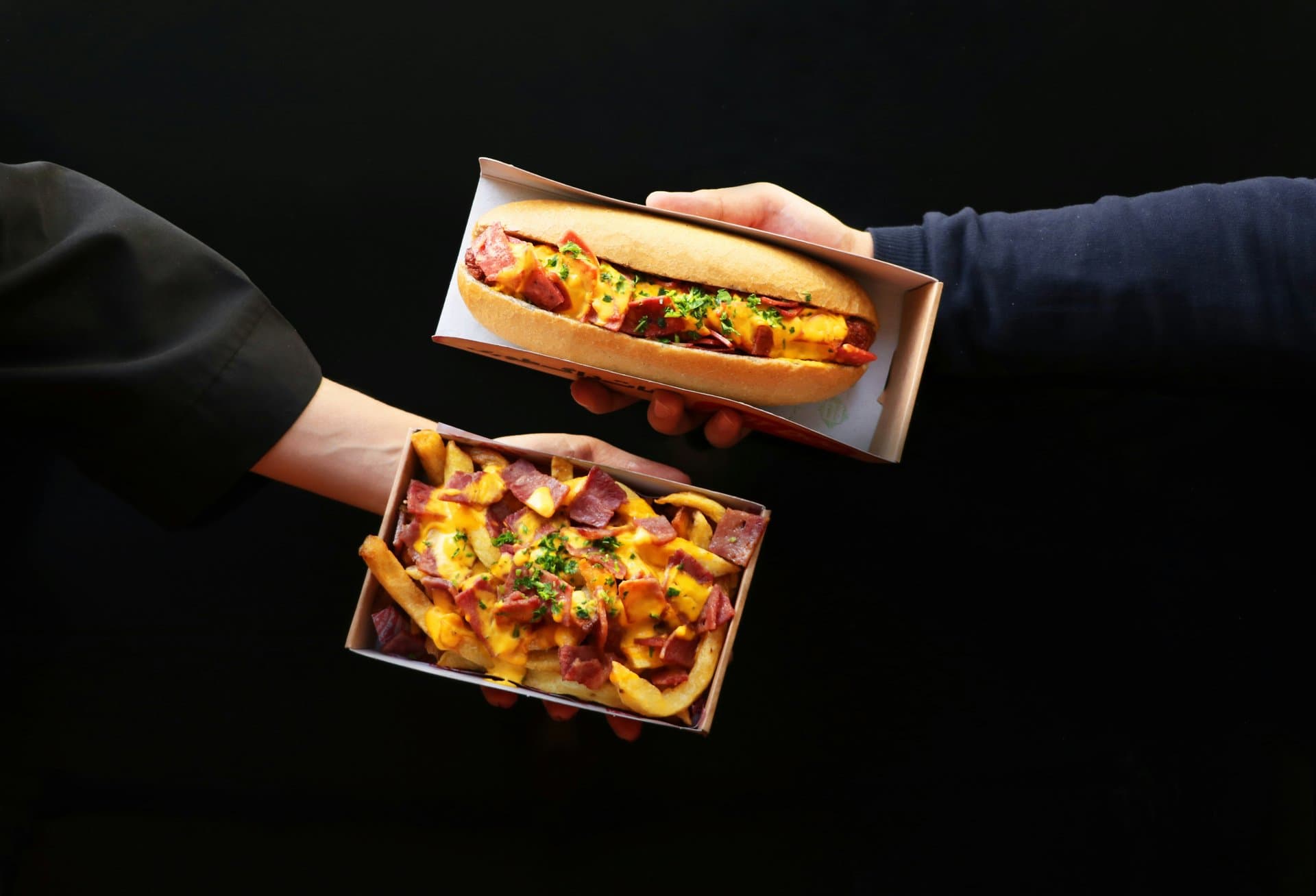 2 hands holding junk food